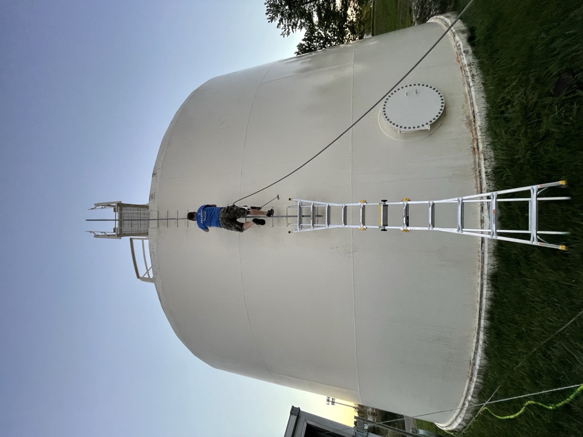 Water tank power washing in progress